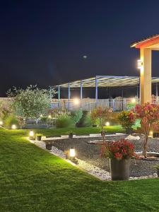 Al Khatimمزرعة واستراحة الجوري的花园中的一个晚上有灯的建筑