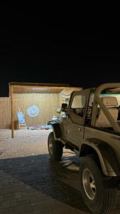 Al Khatimمزرعة واستراحة الجوري的一辆绿色吉普车在晚上停在街上
