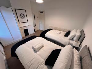 卢顿Visit Luton With This 2 BR Rental - Sleeps 6的客房设有两张床和壁炉。