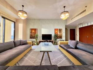 迪拜AR Holiday Home JBR 2的客厅配有沙发和桌子