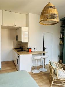里尔Appartement Chaleureux en Hyper Centre à Lille的厨房配有白色橱柜和桌椅