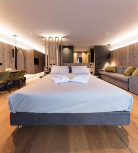 博萨迪法萨DOLOMITI EXCLUSIVE YOUR MOUNTAIN SUITE的一间大卧室,配有一张大床和一张沙发