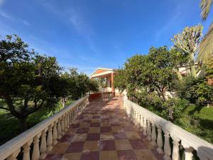 阿加迪尔Tiguimi Vacances - Oasis Villas, cadre naturel et vue montagne的通往树木繁茂的建筑的步行道