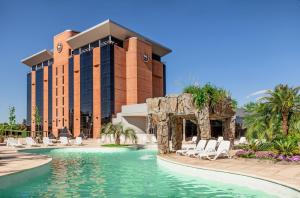 圣米格尔·德·图库玛图库玛喜来登酒店的一个带游泳池和椅子的度假胜地和一座建筑