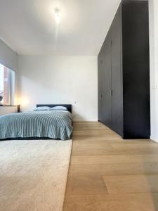 布鲁塞尔Cosy Apartment Brussels - Cinquantenaire的一间卧室配有一张床和一个黑色衣柜