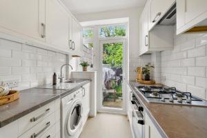 伦敦Wembley Hububb Stay的白色的厨房设有水槽和炉灶。