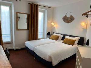 巴黎贝斯特韦斯特阿拉米圣日耳曼酒店的卧室配有一张带黄色枕头的大型白色床。