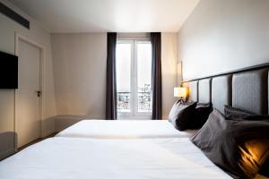 巴黎Hotel de Flore - Montmartre的一间设有大床和窗户的酒店客房