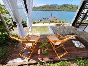 安格拉杜斯雷斯Oásis Beach House的一个带两把椅子和热水浴缸的庭院
