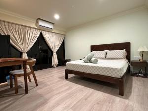 浮罗山背宝胜榴莲农场酒店的卧室配有床、书桌和钢琴
