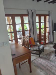 马林迪Cosy Cottage Marine Park at Malindi beach的带沙发、椅子和窗户的客厅