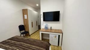 TengizSulimen Camp的一间卧室配有一张床,墙上配有电视