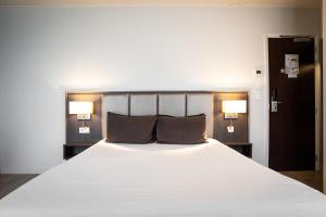 巴黎Hotel de Flore - Montmartre的卧室配有一张带两个枕头的大白色床
