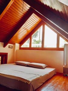 黎明之村Little Things Earth - Pine villa的一间卧室设有一张大床和大窗户