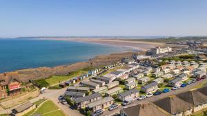 韦斯特沃德霍Deluxe Lundy View Villa With Sea Views的海滩旁一排房子的空中景色