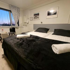 凯夫拉维克凯夫拉维克中心食宿酒店的一间卧室配有一张大床,铺有黑白床单。