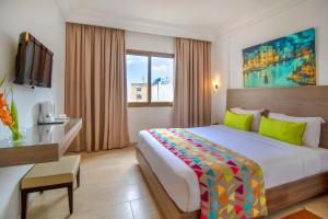 突尼斯El Oumara Hotel的酒店客房设有一张大床和一台电视。