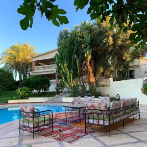 阿加迪尔Tiguimi Vacances - Oasis Villas, cadre naturel et vue montagne的一组椅子和一张桌子,旁边是游泳池