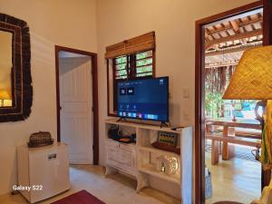 托兰克索Mini Casa com Jacuzzi e Piscina的客厅配有台面上的平面电视