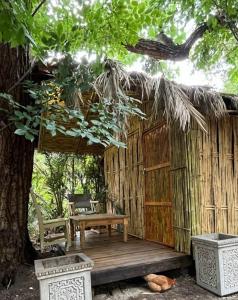 约翰内斯堡Sandton Safari Camp的木甲板上设有长凳和一棵树
