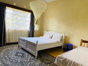 基塔莱Lisa place milimani的卧室配有白色的床和窗户。