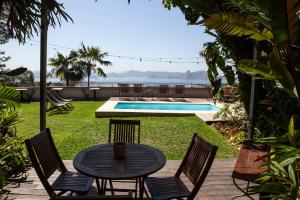 里约热内卢哥特鲁特住宿加早餐旅馆的一个带桌椅的庭院和一个游泳池