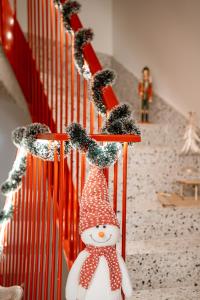 奥拉迪亚26Bricks Luxury Suites的楼梯上一个拥有圣诞装饰的雪人