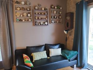 VitréLa mare au Loup的客厅配有带枕头的黑色真皮沙发