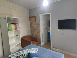 加罗帕巴Moradas Vô Ary的一间带床和电视的客厅以及一间房间