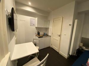 阿姆斯特丹City Center Studio Amsterdam的一间小厨房,配有白色的桌子和白色的门