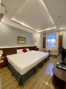 吉婆岛Dolphin Hotel的卧室配有一张白色大床和一张书桌
