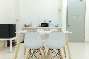 雪邦FxA Studios Core Soho Suites KLIA 1 & 2 FREE WIFI的厨房配有白色的桌子和4把白色的椅子