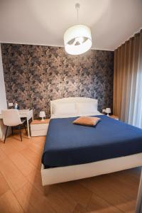 巴勒瑟Wojtyla Bari Airport的一间卧室配有一张带蓝色毯子的大床