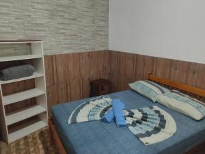 加罗帕巴Moradas Vô Ary的一间卧室设有一张床和一个书架