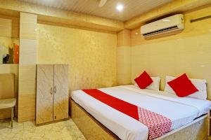 加尔各答Hotel Royal Inn的一间卧室配有红色枕头的床
