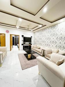 伊斯兰堡BED AND BREAKFAST ISLAMABAD - cottages的客厅配有白色家具和电视