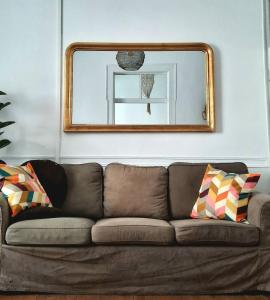 蒙希克Casa Malva - Traditional townhouse apartment的客厅里一张带镜子的棕色沙发