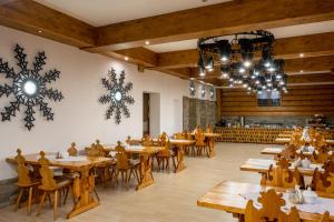 扎科帕内Dom Wczasowy Grań的餐厅设有木桌、椅子和吊灯。