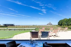 圣米歇尔山圣米歇尔驿站酒店的享有带椅子和桌子的庭院的景色。