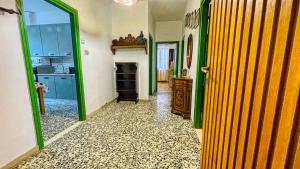 巴多尼奇亚Appartamento La Gare - Affitti Brevi Italia的带绿色和黄色门的厨房以及带壁炉的客房。