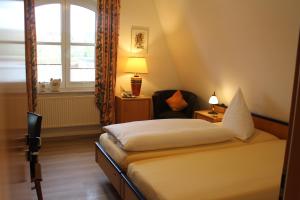 瓦伦多夫Gästehaus Niemerg的卧室配有床、椅子和窗户。