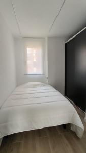 马德里Exyca Metropolitano的窗户客房内的一张大白色床