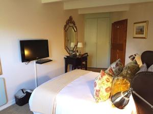 Bagua GrandeHOTEL VIP 46 SSQS的一间卧室配有一张床、镜子和电视