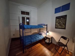 瓦尔帕莱索爱斯卡拉巴乔旅舍的一间卧室配有两张双层床和椅子