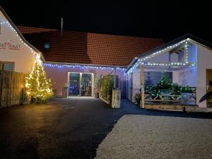 当巴克拉维尔Le Refuge du Rempart的装饰有圣诞灯和圣诞树的房子