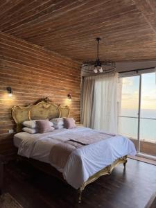 亚历山大Sea View Cabin的一间卧室设有一张带木墙的大床