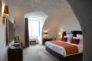 梅屈埃斯梅屈埃斯城堡酒店的一间卧室设有一张大床和一个窗户。