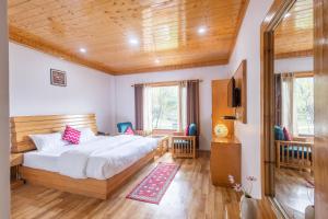 马拉里Aroha Residency- A Countryside Resort的一间卧室设有一张大床和木制天花板