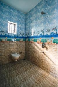 巴加Hotel Pasquina Baga的蓝色墙壁的客房内设有带卫生间的浴室