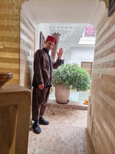 马拉喀什里亚德马拉喀什之夜酒店的站在房子走廊上的男人